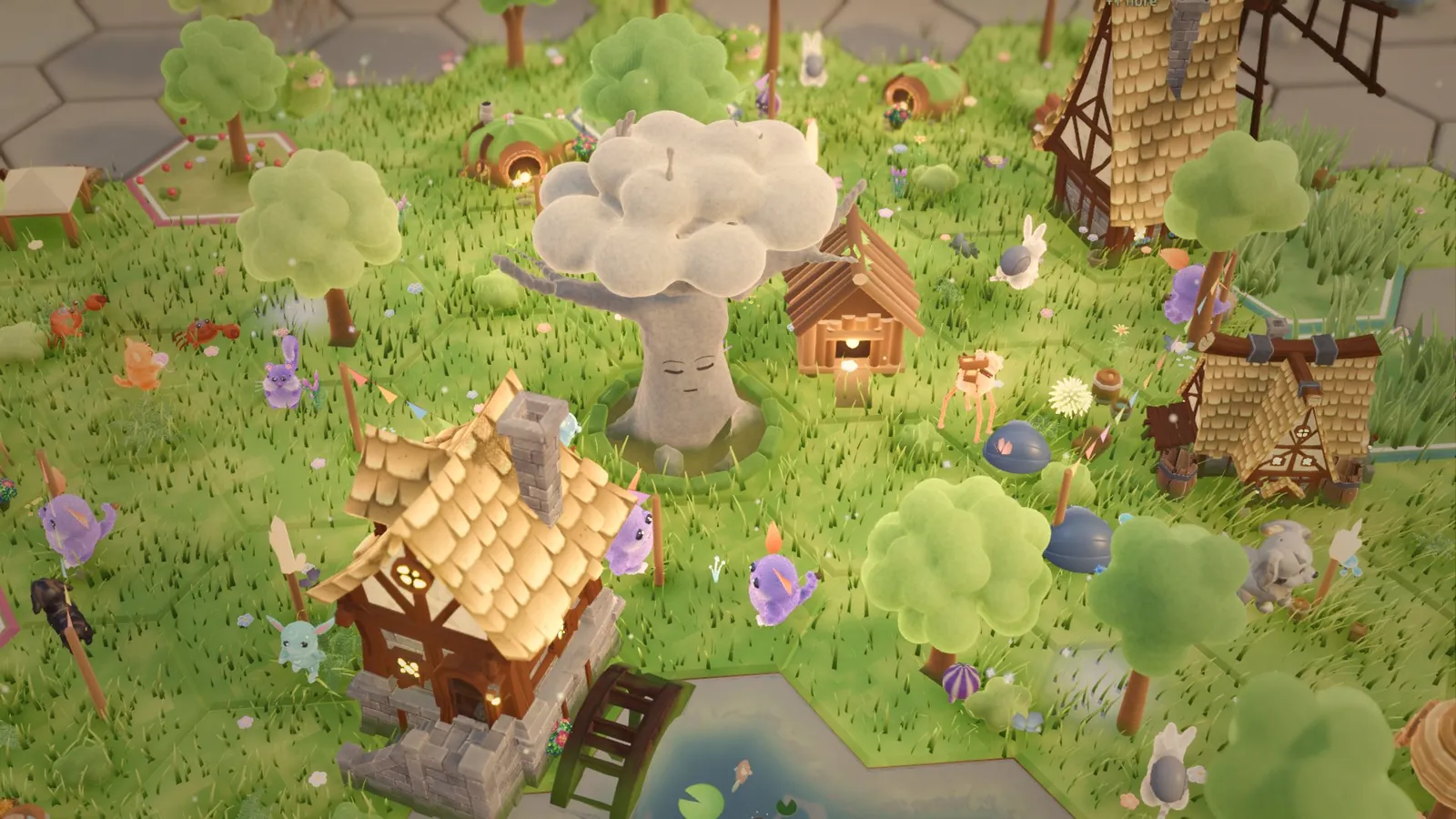 The village by day: the Old Tree, huts, creatures at work and a pond on green hexes